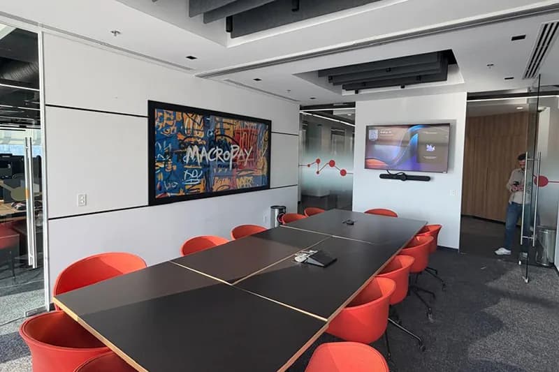 Sala de consejo con mesa amplia y pantalla en una sede Flexo